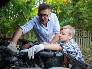 Dad teaching his son about car maintenance 