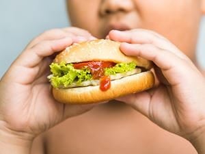 boy overweight eating sandwich