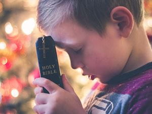 boy praying with bible