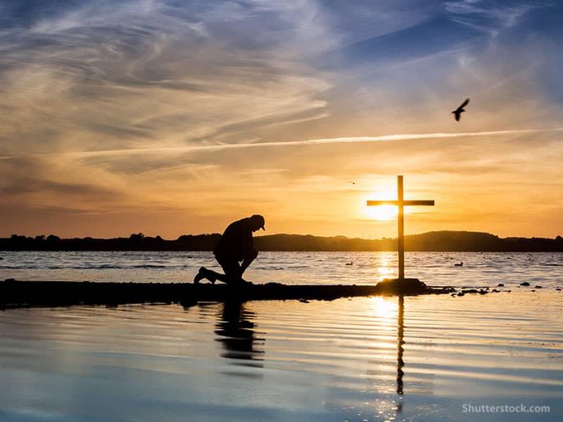 man-kneeling-prayer-cross-water