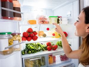 woman looking in refrigerator