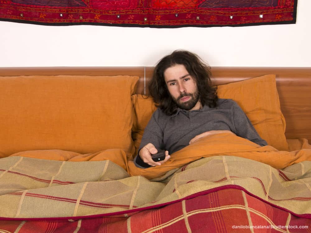 Man Watching TV in Bed 