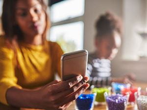 woman ignoring her child for her cell phone