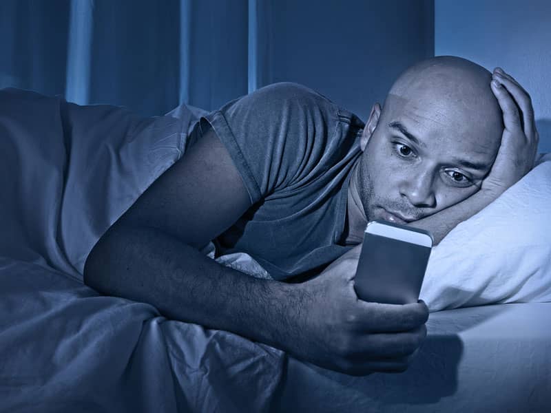 Man on Phone in Bed