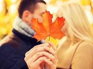 Man and woman kissing behind leaf