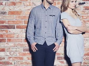 Man and woman standing at a brick wall