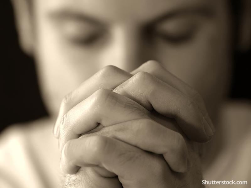 man-praying-sepia