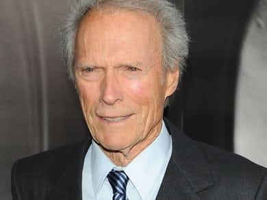 Clint Eastwood, in a suit, smiling