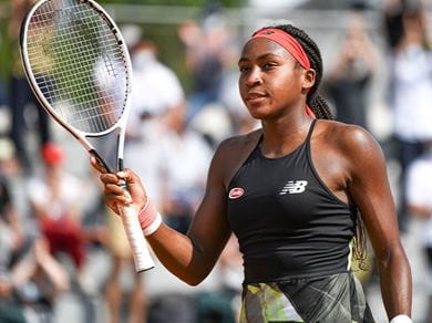 Coco Cauff holds a tennis racquet after winning a tournament