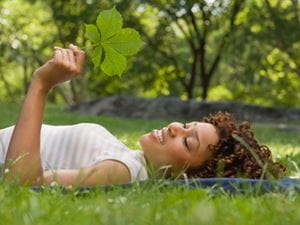 Thoughful woman holding a leaf in the summer