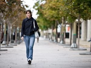 Woman walking on sidewalk