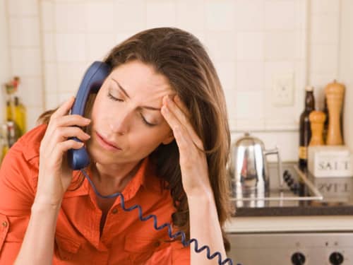 Woman with headache on phone