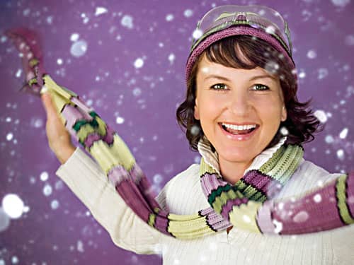 Happy woman in snow on violet