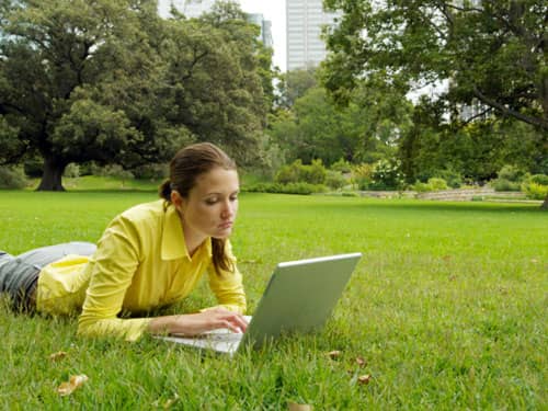 Girl relaxing outside with laptop