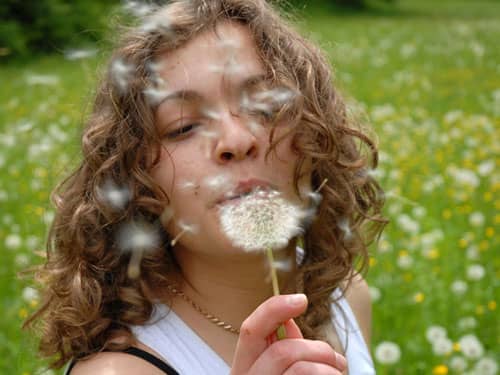 Woman blowing dandelion