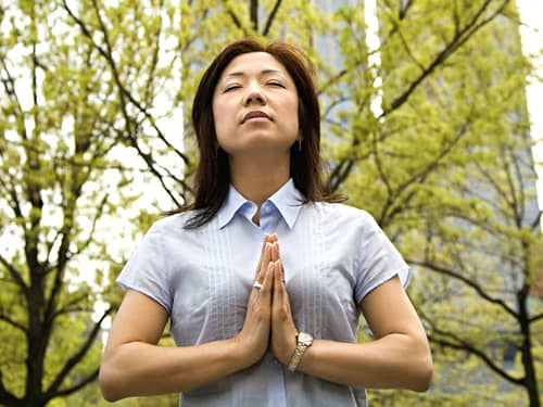 Asian woman meditating in the wood