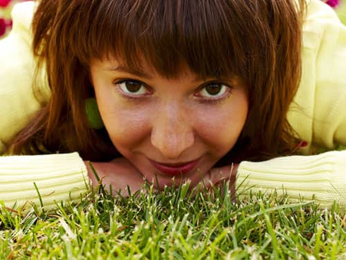 Woman staring up from the grass