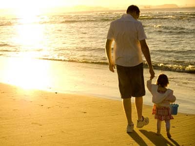 Father walking with daughter on a beach