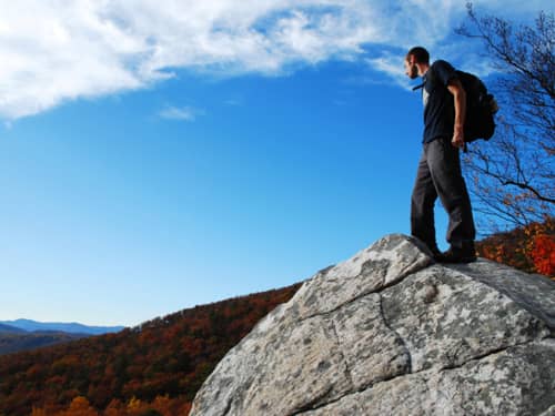 Man standing on rock looking over landscape