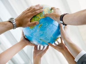 Many hands touching globe