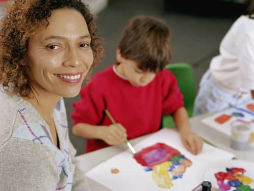woman smiling and child painting