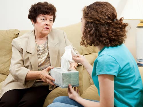 Woman gives tissues to a young girl