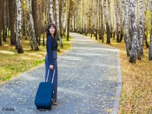 Woman with suitcase looking behind her